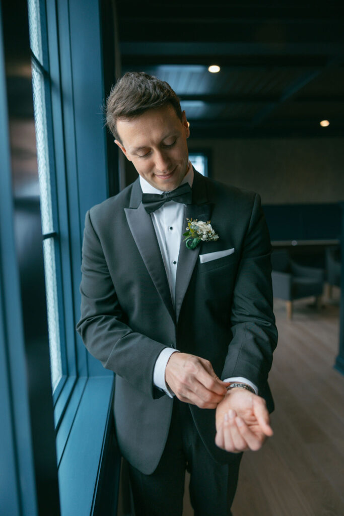 Groom getting ready with watch at jersey shore wedding venue getting ready suite